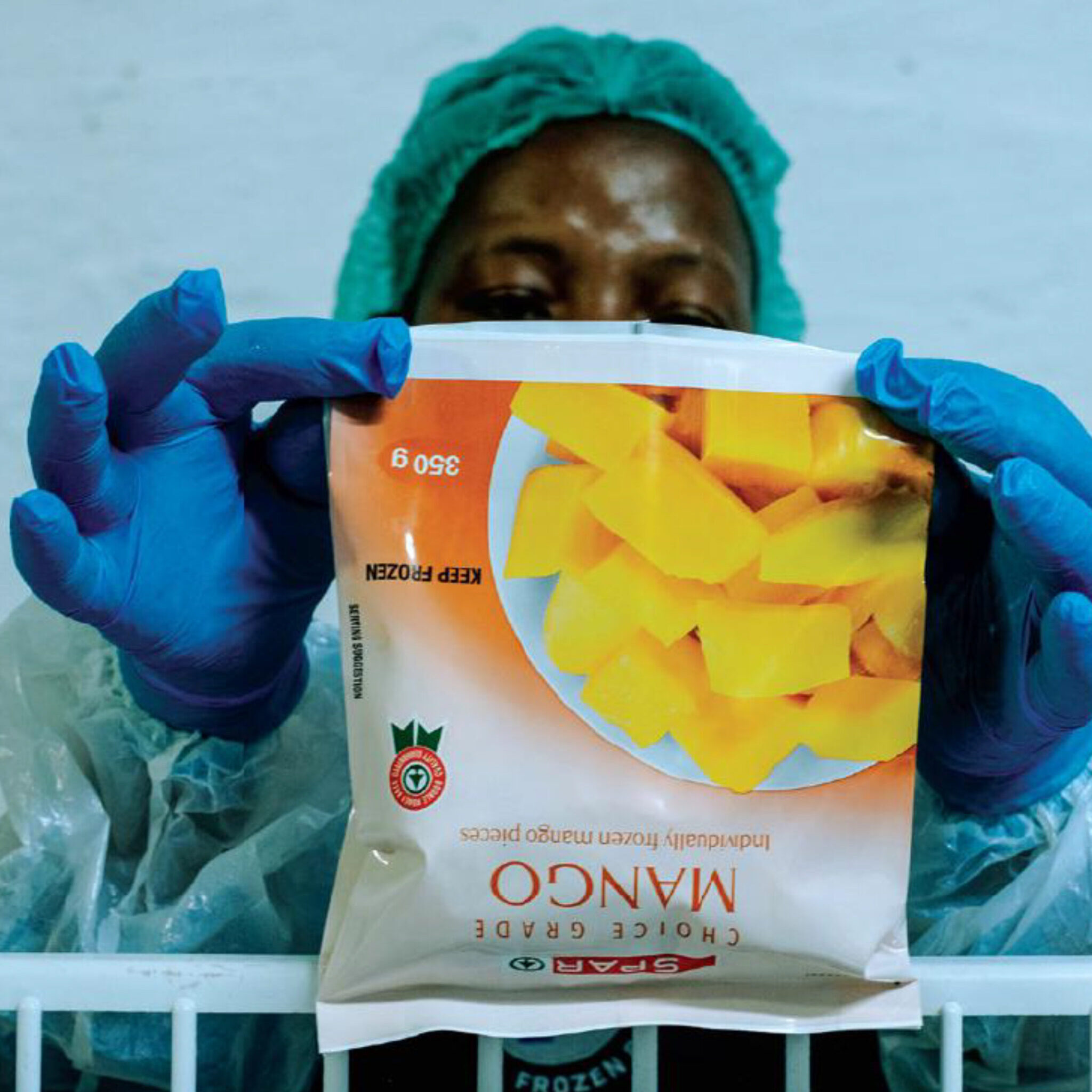 Private Label Product Development – Our Offering – Frozen Brands Factory worker holding up a bag of frozen fruit labeled