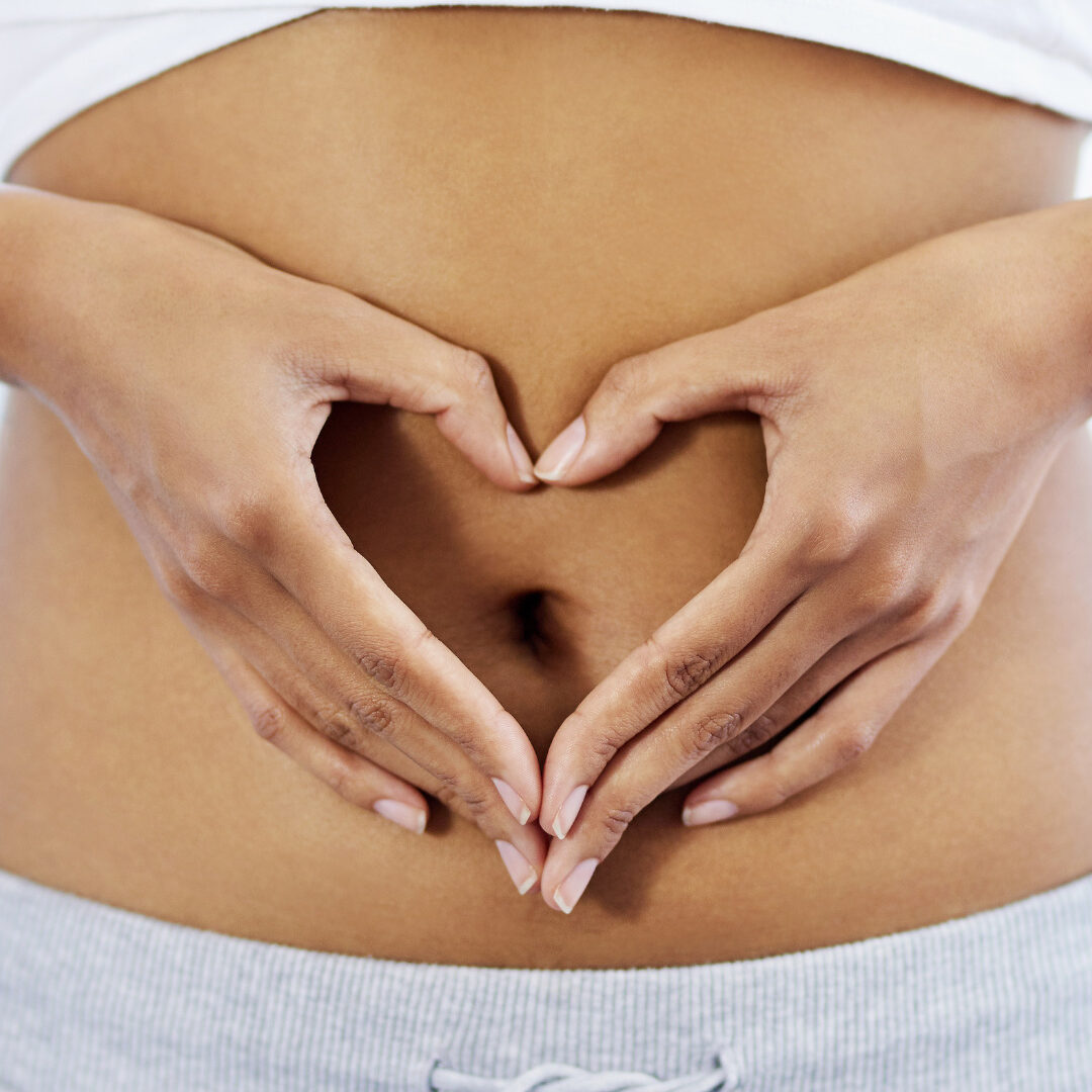Nutraceuticals – Our Offering – Frozen Brands Lady making the shape of a heart with her hands, surrounding her belly button.