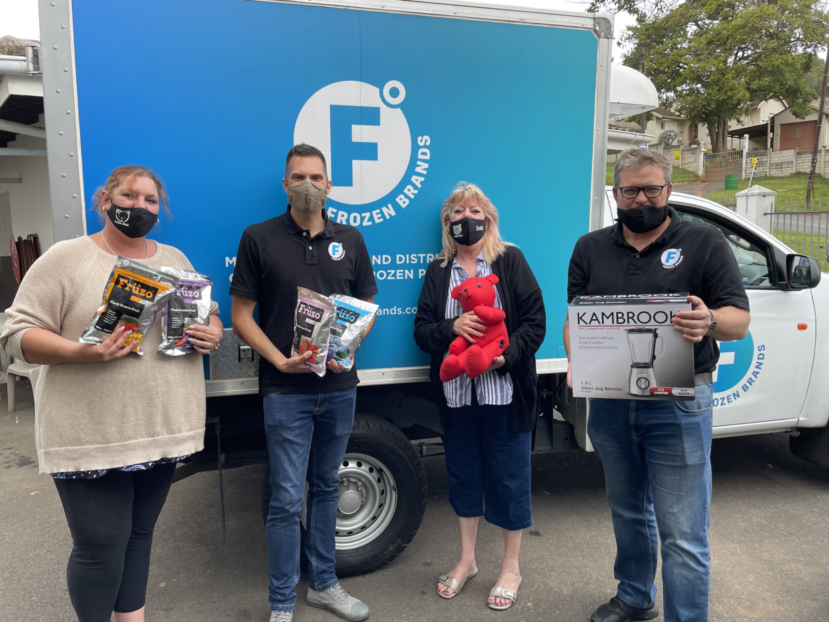 Representatives from Frozen Brands and Bobbi Bear together in front of a Frozen Brands delivery truck.